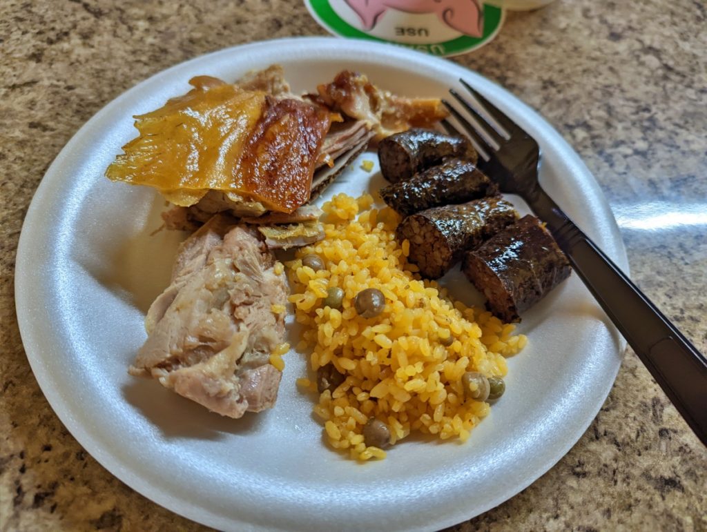 Plate of lechon, arroz con gandules, and morcilla