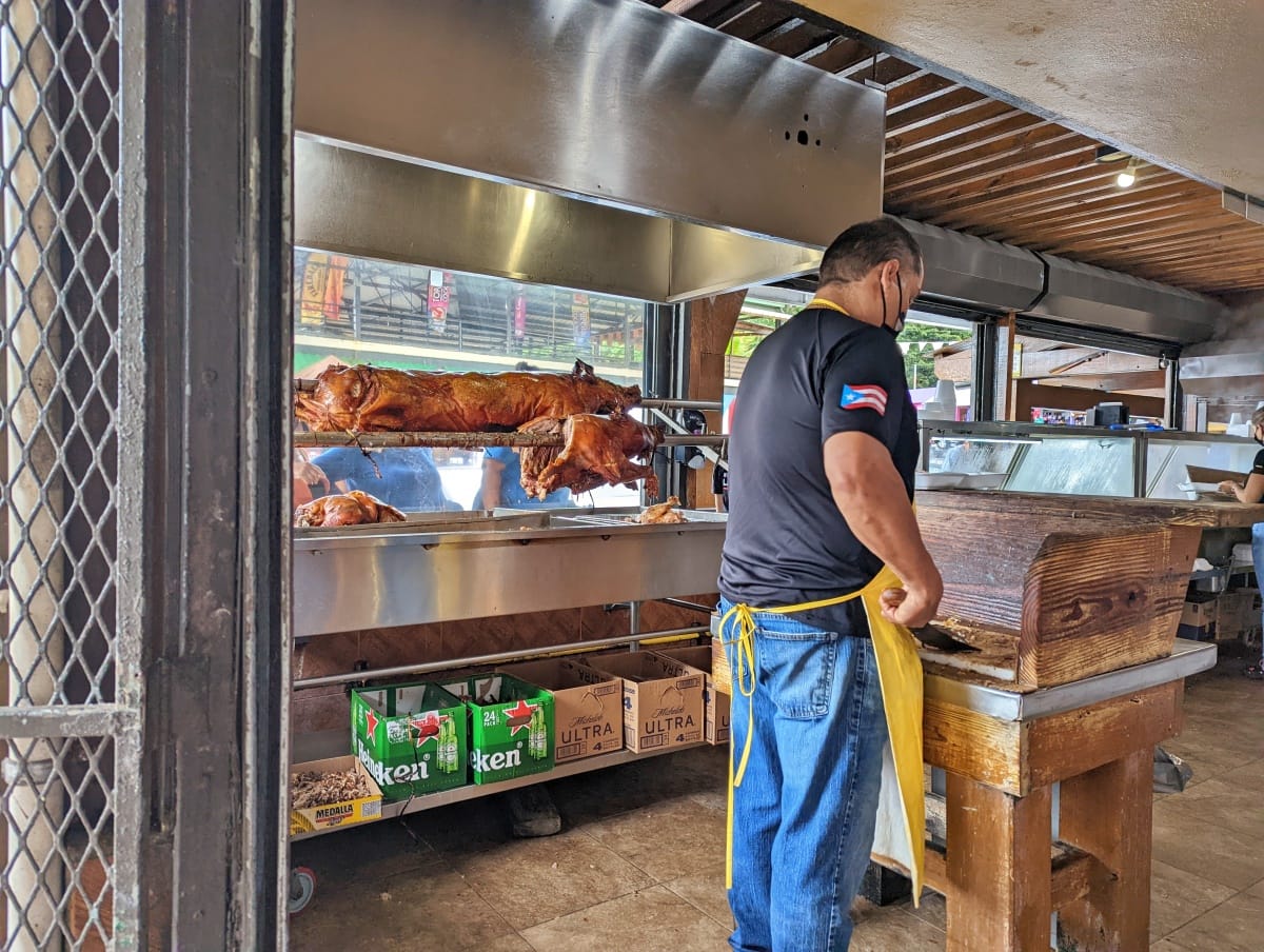 man with machete cutting pork on La Ruta del Lechon